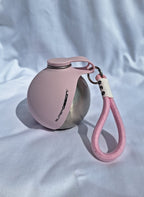 Gourde pour chien rose, fermée, avec gamelle repliée et dragonne